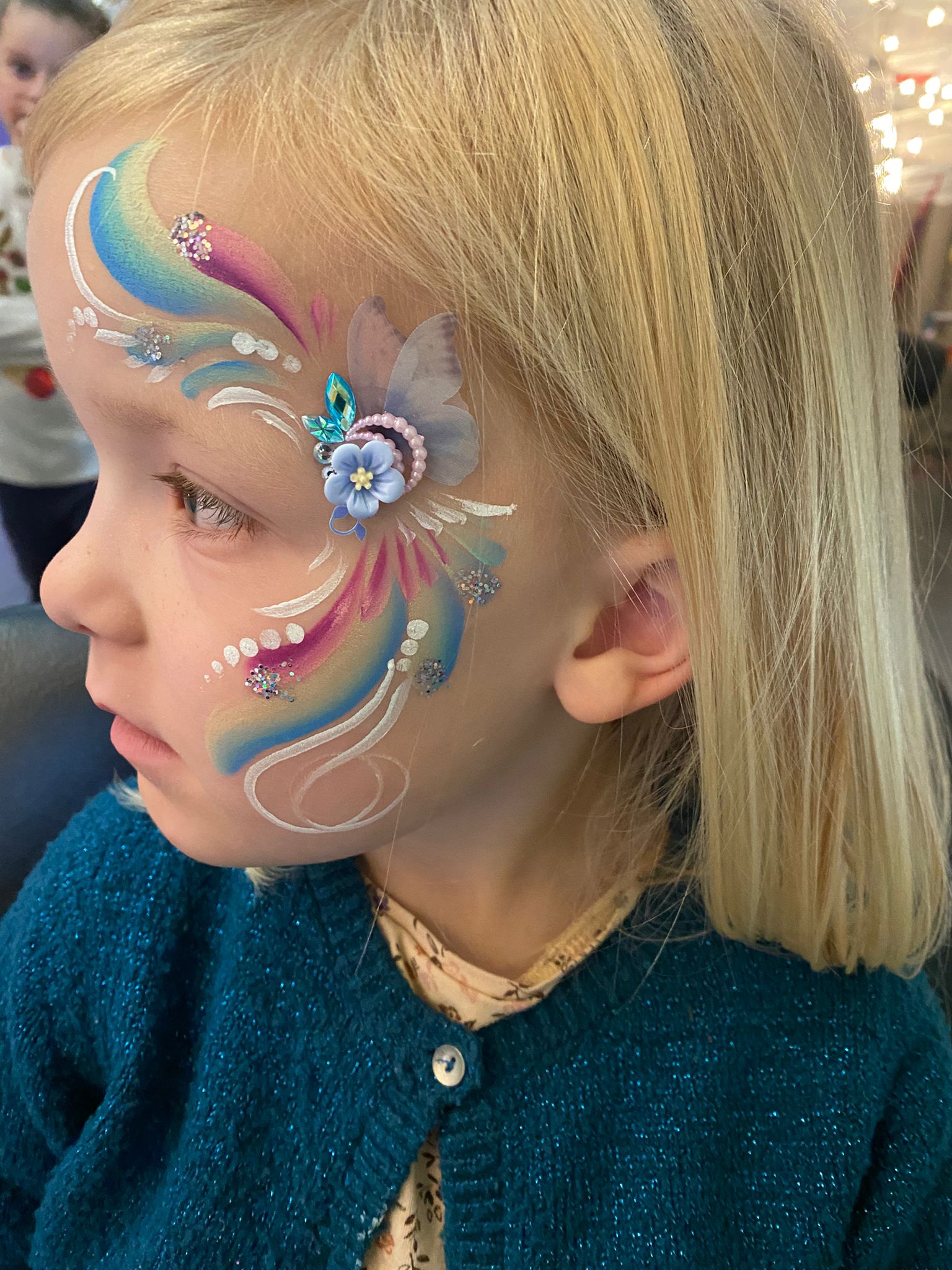 Petite fille blonde avec maquillage floral pastel orné d un papillon et d une fleur en relief